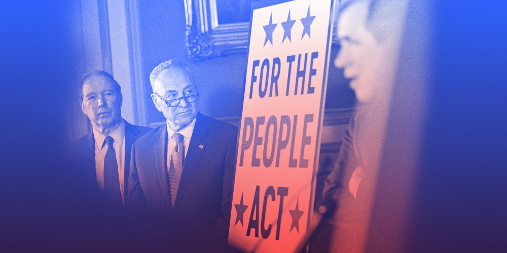 Image: Chuck Schumer stands next to a board that reads,"For the People Act".