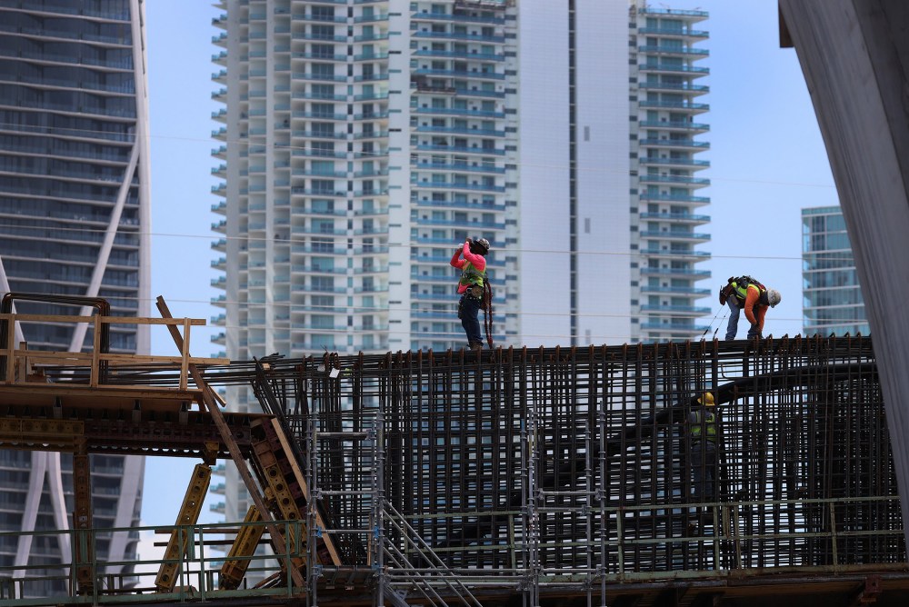 Image: Construction workers build the 'Signature Bridge' replacing and improving a busy highway intersection at I-95 and I-395 in Miami, Fla.