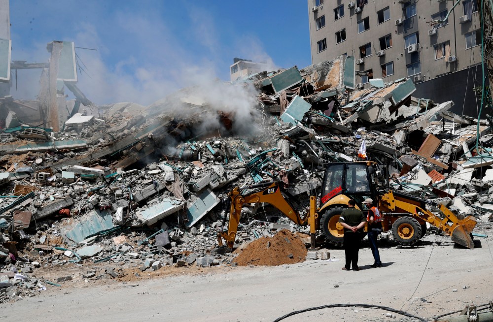 Workers clear rubble from a building that was destroyed by an Israeli airstrike on Saturday that housed The Associated Press, broadcaster Al-Jazeera and other media outlets, in Gaza City on May 16, 2021.