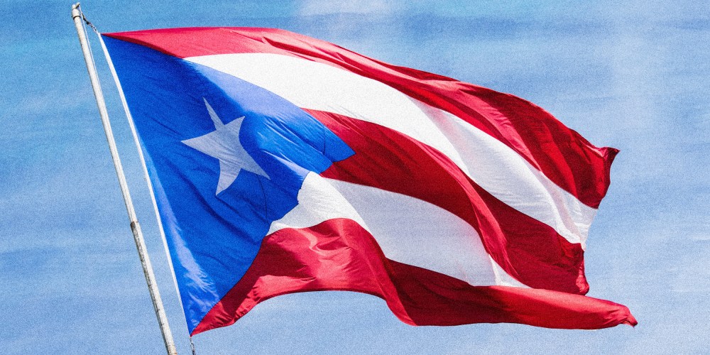 Photo illustration: A Puerto Rican flag waving in the sky.