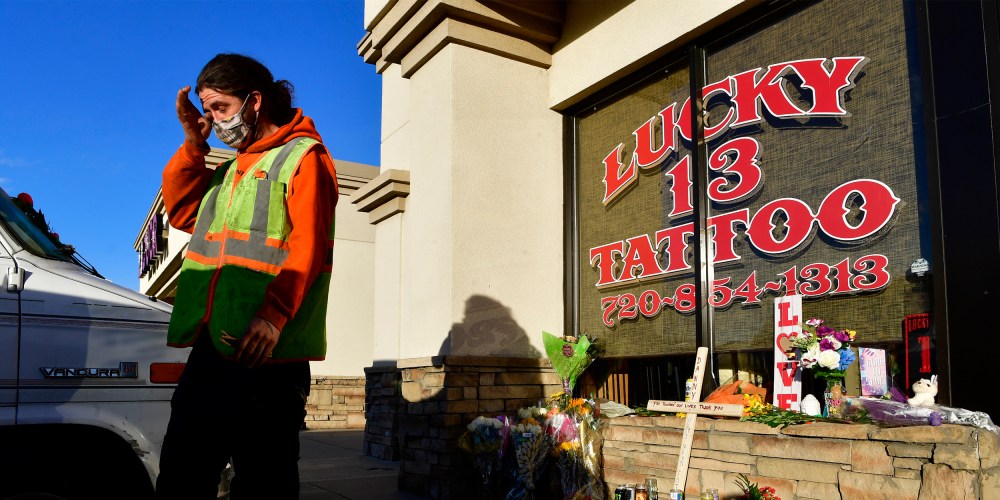 Image: Dylan Danielson wipes away a tear near on a small memorial outside Lucky 13 Tattoo and Body Piercings.
