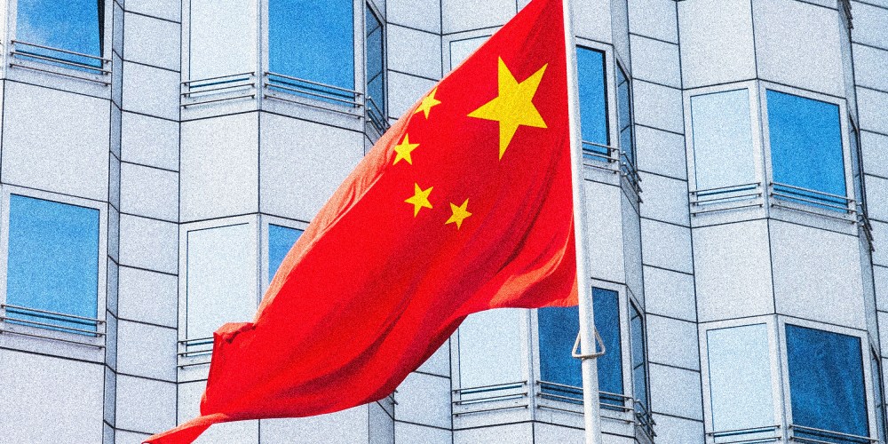 Image: The Chinese flag flying outside a building.