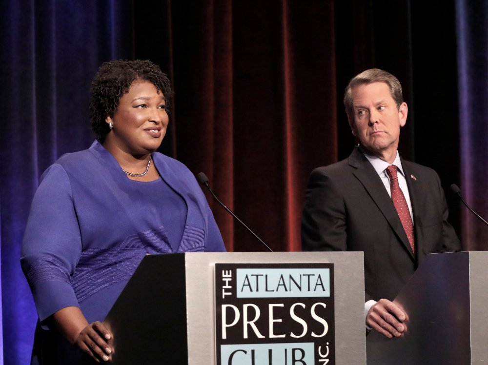 Democratic gubernatorial candidate for Georgia Stacey Abrams speaks as her Republican opponent Secretary of State Brian Kemp looks on during a debate in Atlanta, Georgia, October 23, 2018.