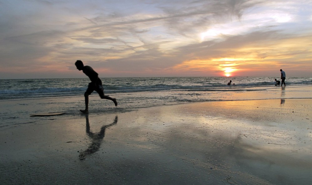A beachgoer jumps on his 'boogie board' at sunset on a beach in Bradenton, Florida, May 18, 2010.