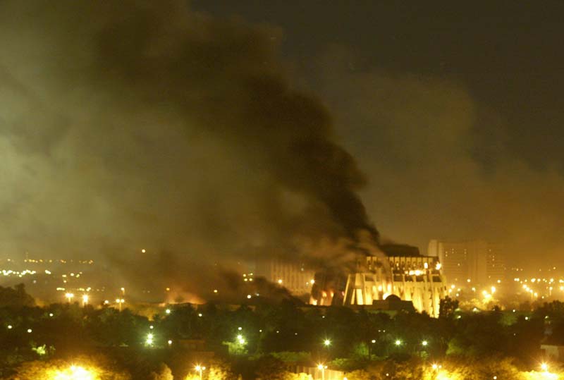 FILE - In this March 21, 2003 file photo, a government building burns during heavy bombardment of Baghdad, Iraq by U.S.-led forces. Almost seven years after the first bombs in the war to oust Saddam Hussein, Iraqis went about their business Friday with...