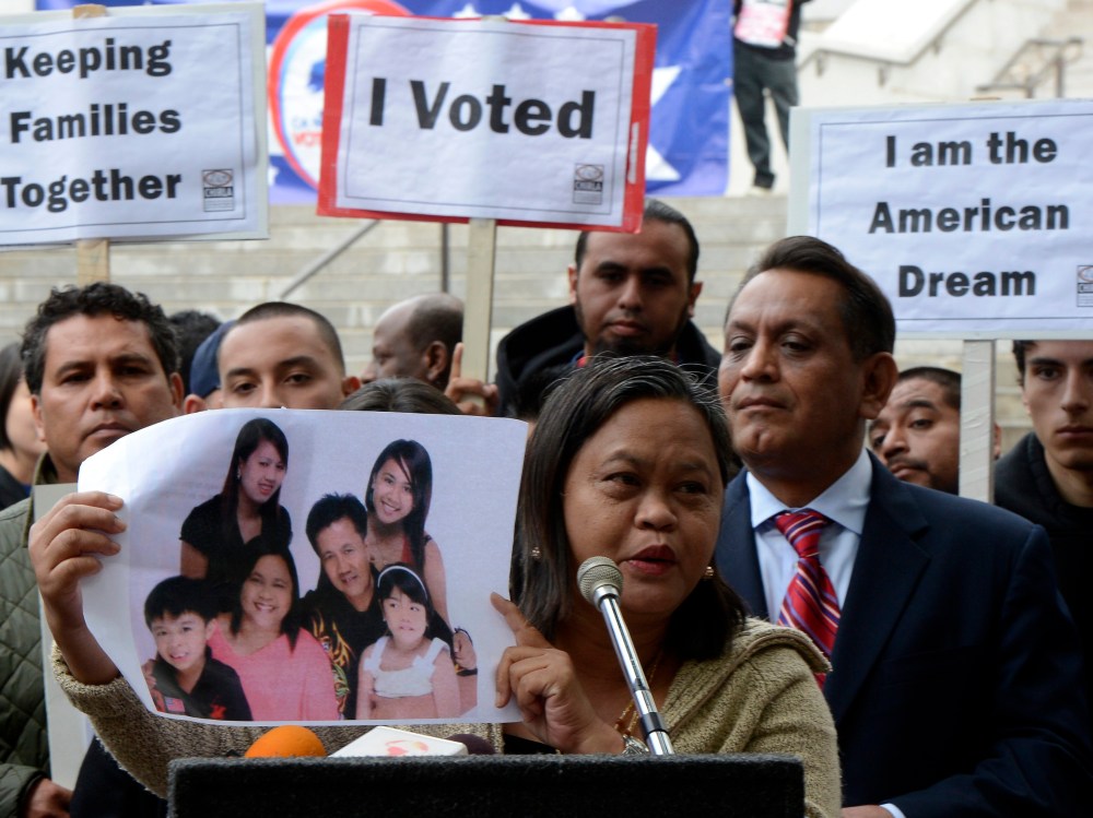 Lolita from the Philippines holds a photograph of her family as she joined other immigrants who gathered in front of Los Angeles City Hall to press for immigration reform following the re-election of US President Barack Obama in Los Angeles, California...