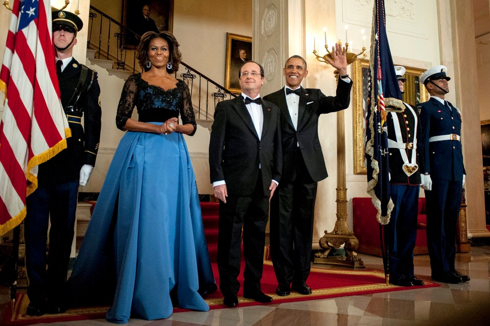 US President Barack Obama and First Lady Michelle Obama pose for a photo with President Francois Hollande of France on the Grand Staircase in the White House in Washington on Feb. 11, 2014.
