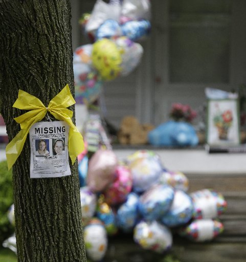 File Photo: A missing poster still hangs on a tree at the home where Amanda Berry is staying in Cleveland on Saturday, May 11, 2013. (Photo by: Tony Dejak/AP Photo)