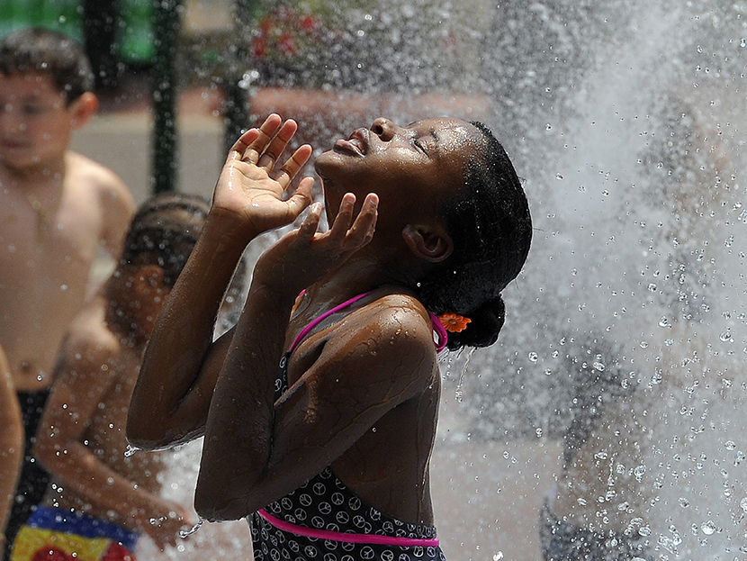 Children cool off during a hot summer day at a fountain in downtown Silver Spring, Maryland, on July 19, 2013.   (Photo by Jewel Samad/AFP/Getty Images)