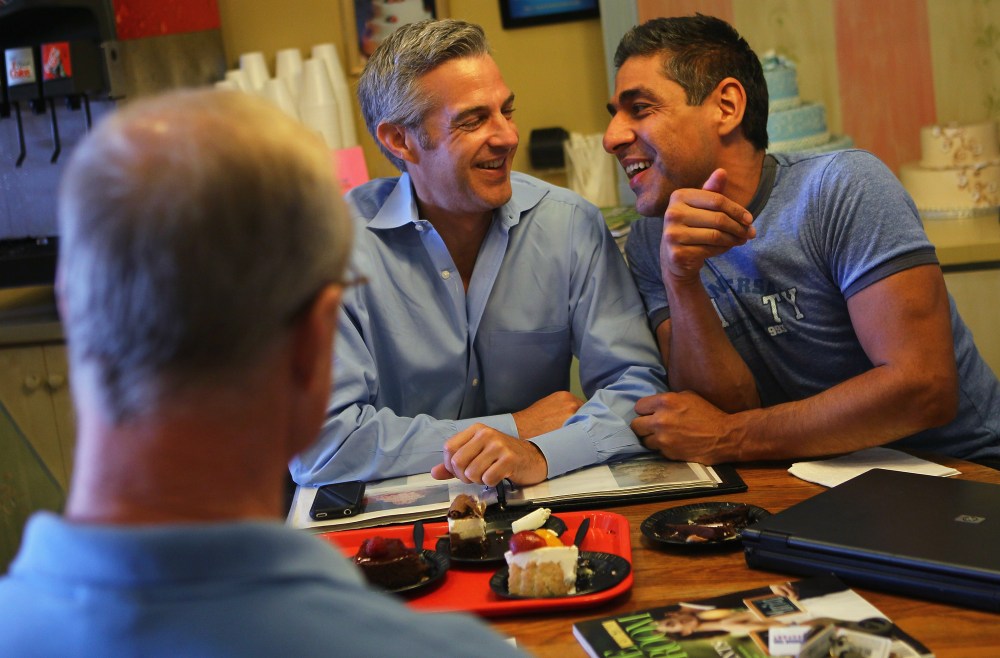 TV reporter Roby Chavez and his partner Chris Roe share a moment as they pick their wedding cake at a bakery in Alexandria, Virginia, July 30, 2010.