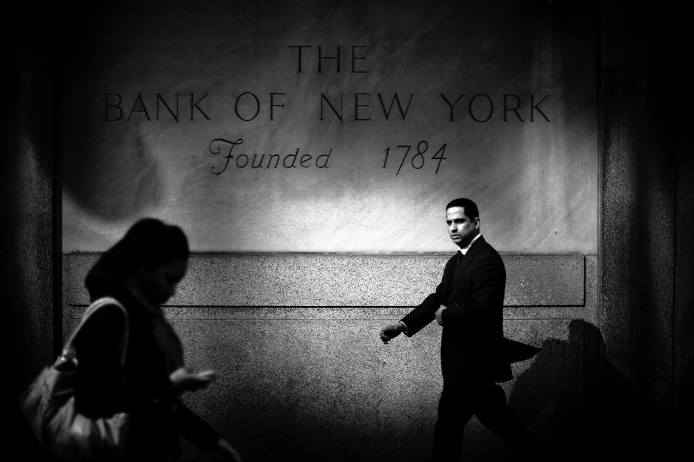 A businessman walks by the Bank of New York in Midtown Mahattan, home to many of the world's banks.