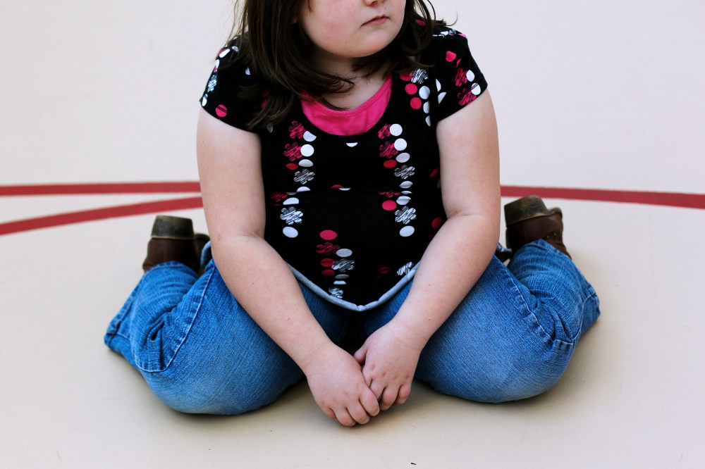 A child sits on the gym floor during the Shapedown program for overweight adolescents in Aurora, Colorado.