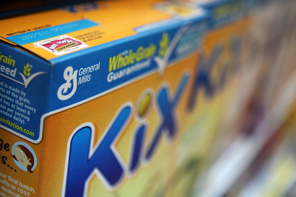 A box of General Mills cereal sits on the shelf.