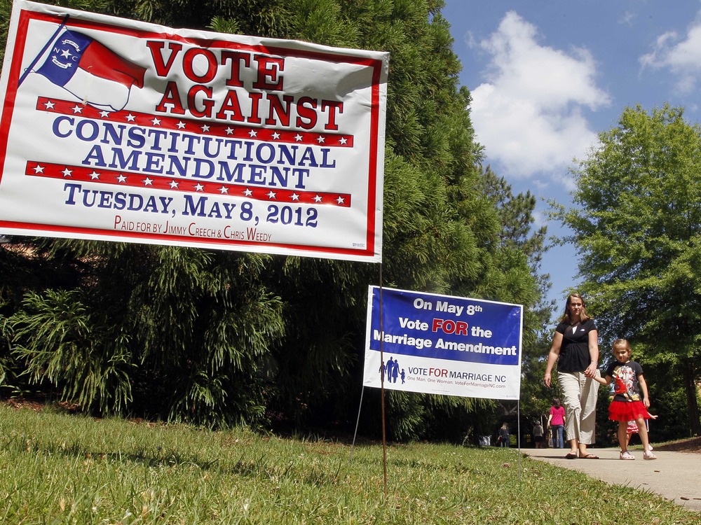 Signs in support of and against the Constitutional Marriage Amendment greet voters at a polling location at Leesville Road Middle School in Raleigh, N.C., Tuesday, May 8, 2012.