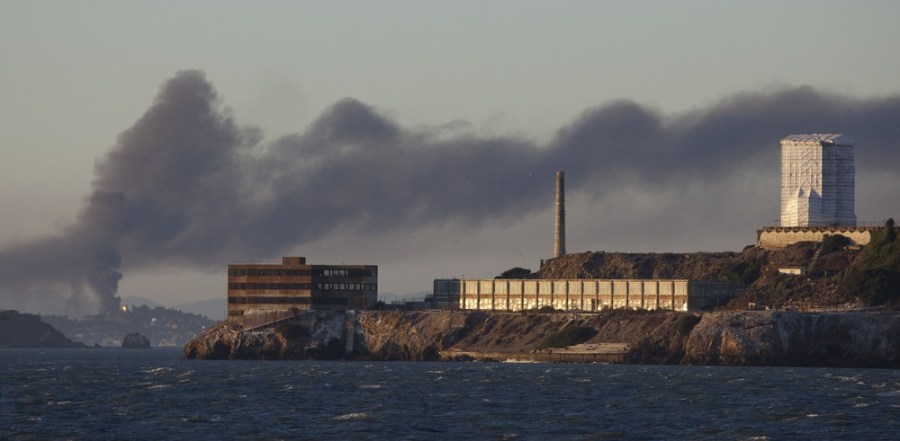 Smoke pours from a fire at the Chevron Richmond Refinery, seen behind Alcatraz Island in San Francisco, Aug. 6. It was sending smoke over the Northern California cities of Richmond and San Pablo.