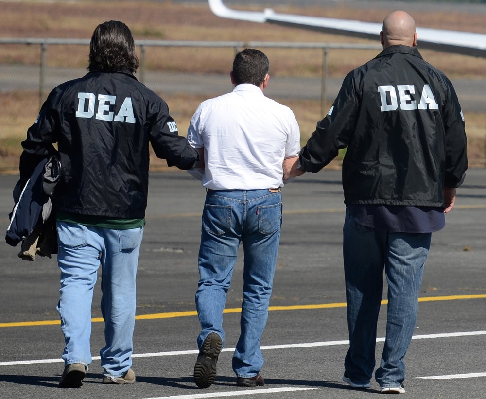 Adrug trafficker Horst Walther Overdick is escorted by DEA agents to a waiting plane during his extradition to the U.S., at an air force base in Guatemala City, Monday Dec. 10, 2012. (AP Photo/Guatemalan U.S. Embassy)