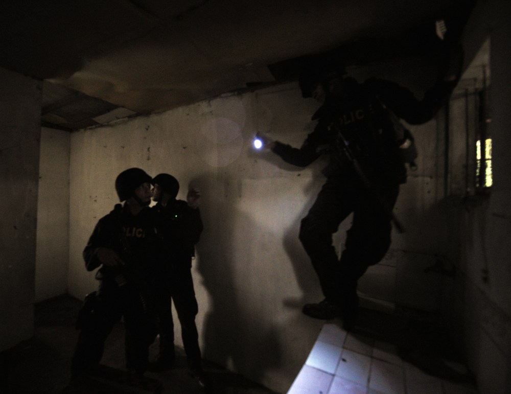 Members of SWAT team search a house for alleged gunmen.