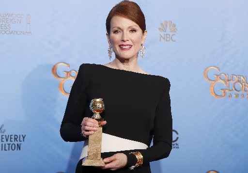 Actress Julianne Moore poses backstage with the awards for Best Miniseries or Motion Picture Made for Television for "Game Change" at the 70th annual Golden Globe Awards in Beverly Hills, California, January 13, 2013. (Photo By: REUTERS/Lucy Nicholson)