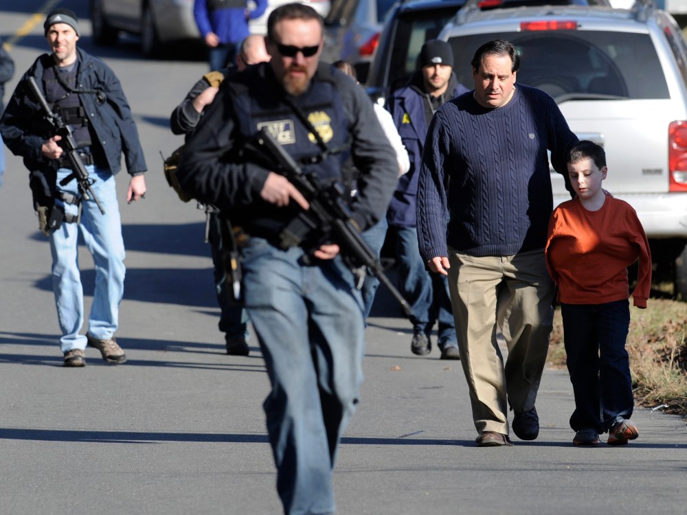 Parents leave a staging area after being reunited with their children following a shooting at the Sandy Hook Elementary School in Newtown, Conn., about 60 miles (96 kilometers) northeast of New York City, Friday, Dec. 14, 2012. (Photo by: Jessica Hill...