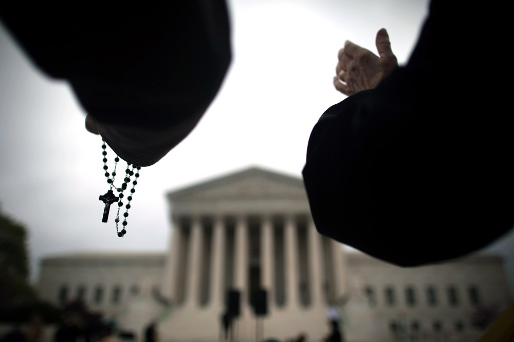 Religious activists lead a prayer vigil outside the Supreme Court on March 25, 2012 in Washington, DC.