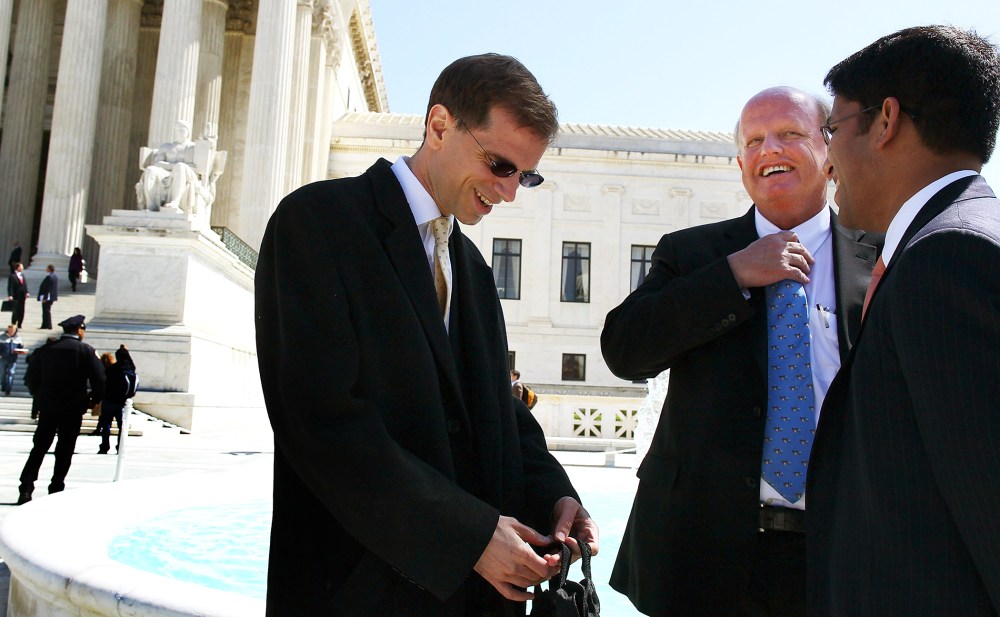 Attorney Michael A. Carvin (2R) stands outside the Supreme Court following the second day of oral arguments for the Affordable Care Act, Mar. 27, 2012.