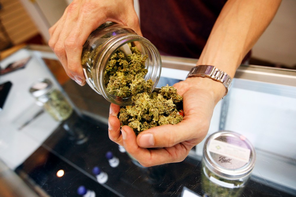 A budtender pours marijuana from a jar at Perennial Holistic Wellness Center medical marijuana dispensary in Los Angeles, California.