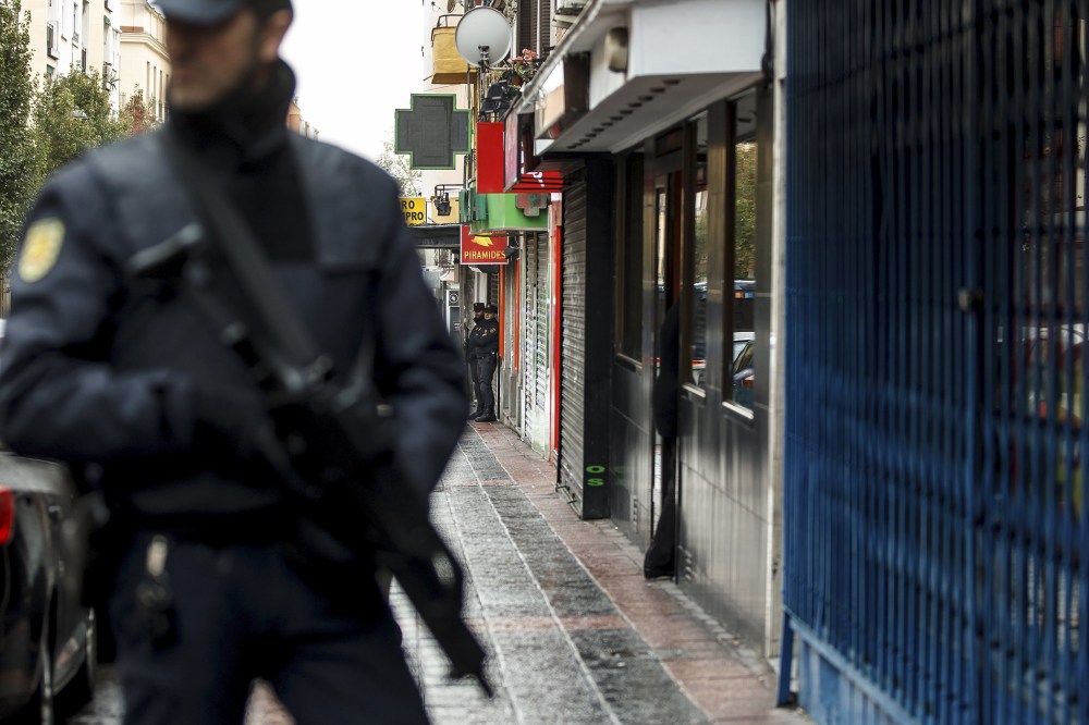 Spanish police stand guard as they search the home of a man suspected to be a member of a group linked to Islamic State in Madrid, Spain, Nov. 3, 2015. (Photo by Reuters)