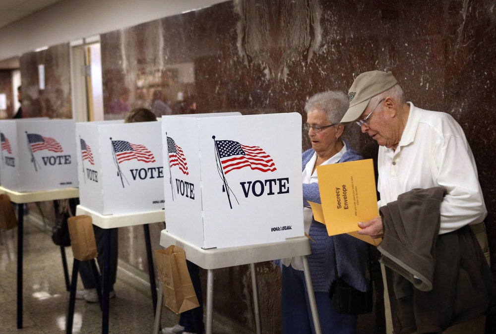 Betty Carlson (L) helps her husband Keith Carlson, who is visually impaired, fill out his ballot during early voting at the Black Hawk County Courthouse on September 27, 2012 in Waterloo, Iowa.