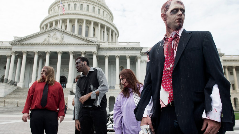 People dressed as zombies stumble across the East Plaza of the U.S. Capitol to promote "The Warehouse: Project 4.1" haunted house in Rockville, Md., on Oct. 3, 2012.