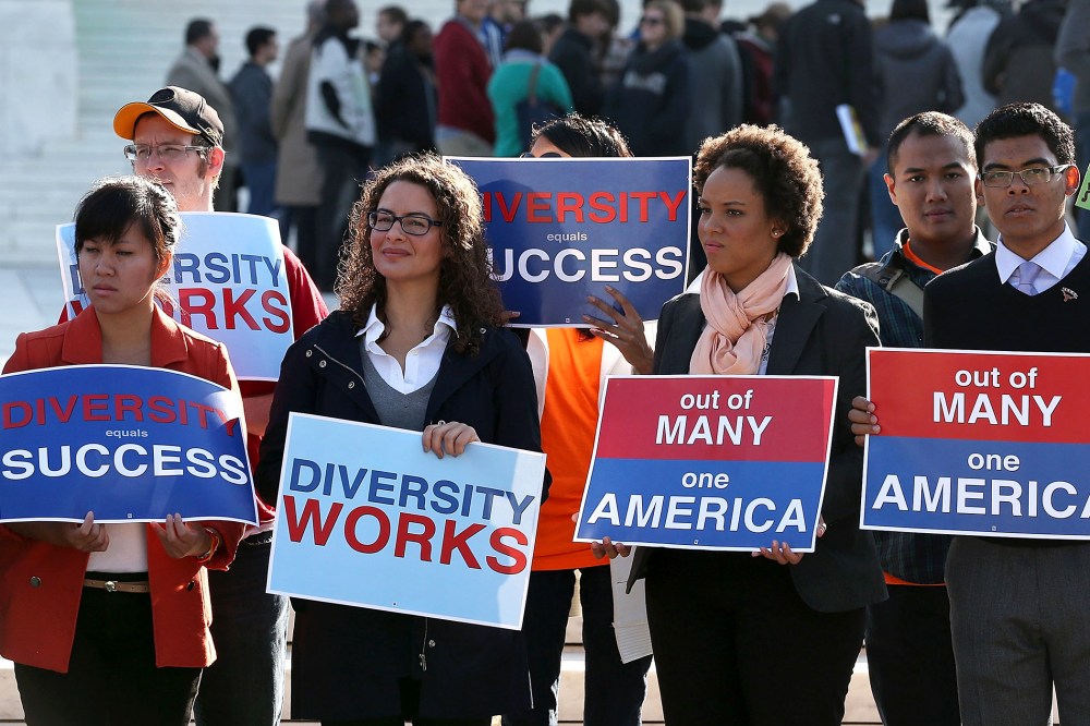 Protesters hold signs in front of the U.S. Supreme Court.