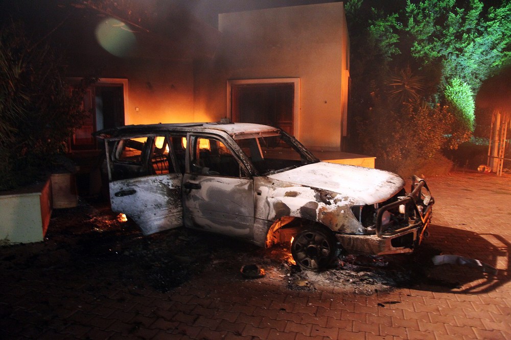 A vehicle and surrounding buildings smoldering after they were set on fire inside the US mission compound in Benghazi, September 11, 2012.