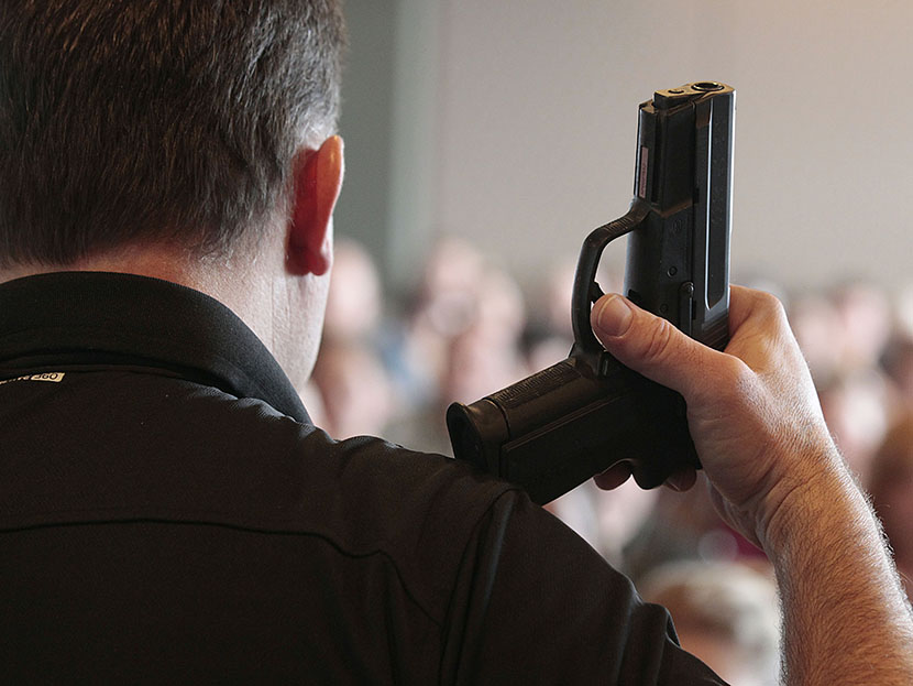 A firearm instructor holds a handgun up as he teaches a concealed-weapons training class to teachers in West Valley City, Utah.