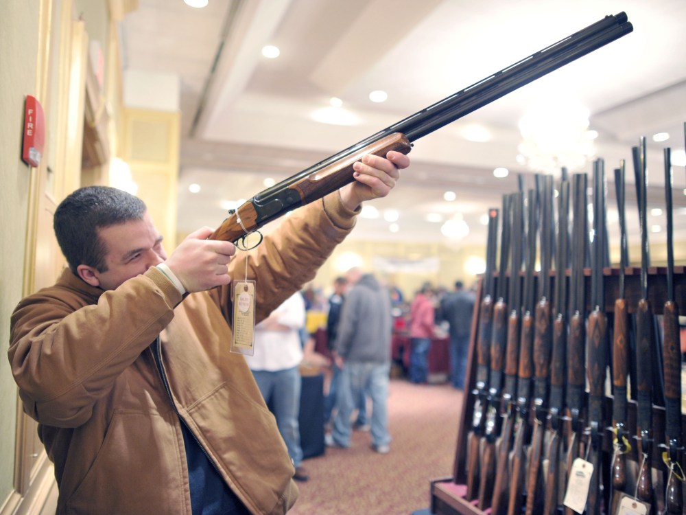 Collin McCarthy of Monroe, Connecticut, looks at a shotgun during the 8th Annual East Coast Fine Arms Show in Stamford, Connecticut January 6, 2013.  (Photo by Timothy A. Clary/AFP/Getty Images)
