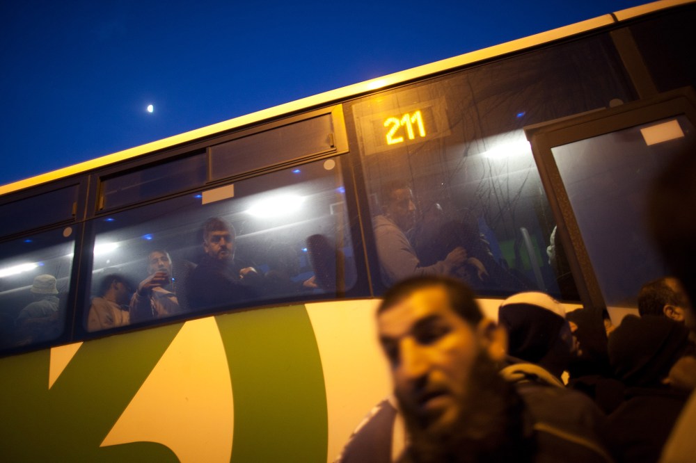 Palestinians board a bus as a new line is made available by Israel to take Palestinian workers from the Israeli army crossing of Eyal, near the West Bank town of Qalqilya, into the Israeli cities, on March 4, 2013. (Photo by Uriel Sinai/Getty)