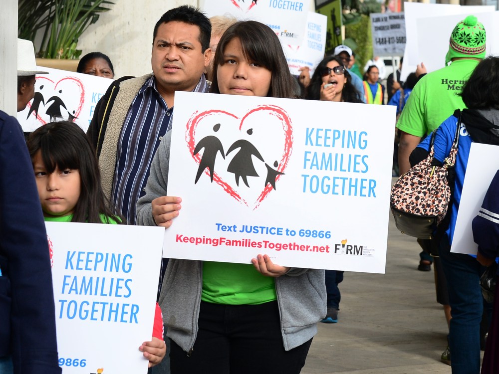 Immigrant families and supporters of their cause hold banners and shout slogans while marching in front of Senator Dianne Feinstein's office on March 4, 2013 in Los Angeles, California, at the launch of a caravan tour called "Our Golden Promise -...