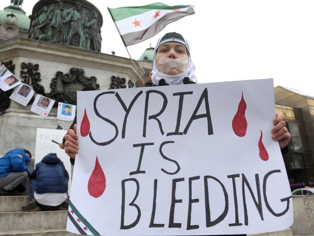 A Syrian living in Serbia displays a placard on March 16, 2013 during a protest against Syria's President Bashar al-Assad in the center of Belgrade. (Photo by Alexa Sankovic/AFP/Getty Images)