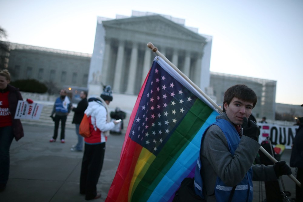 Justin Kenny of Akron Ohio holds a modified Stars and Stripes flag in front of the U.S. Supreme Court, on March 26, 2013 in Washington, D.C.
