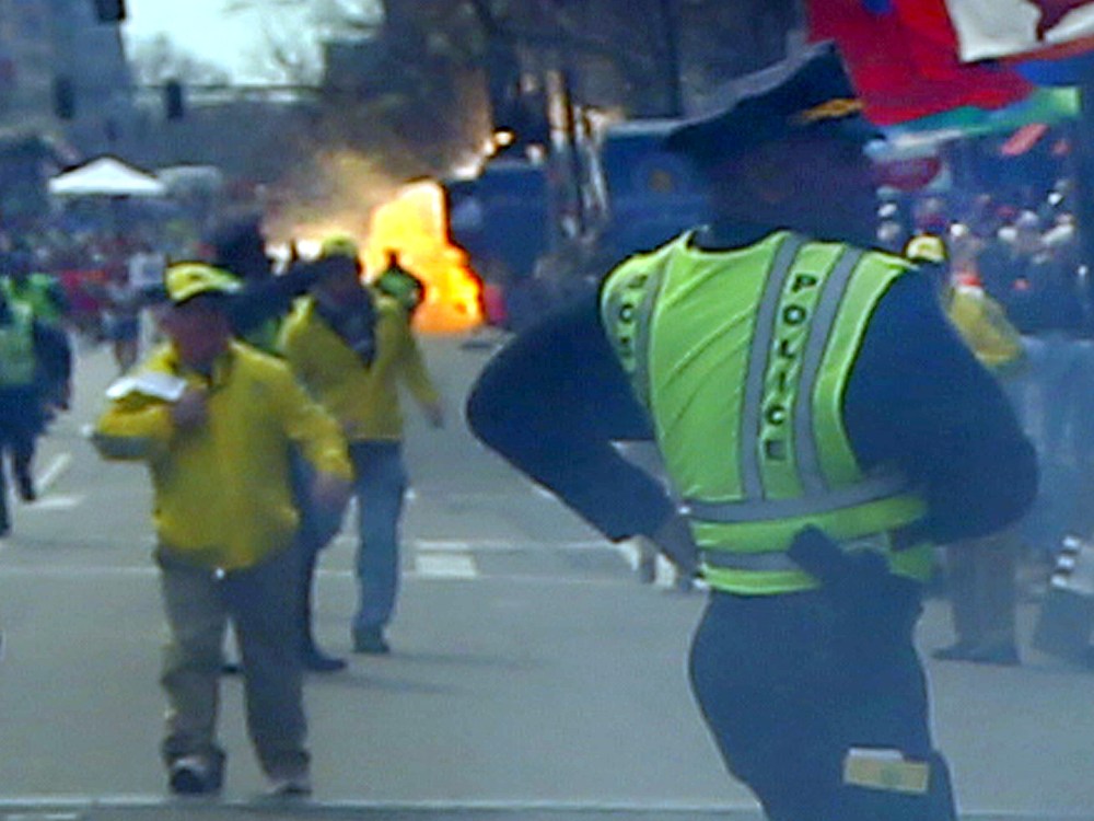 A second explosion goes off (rear) as a runner was blown to the ground by the first explosion near the finish line of the 117th Boston Marathon. (Photo by John Tlumacki/The Boston Globe via Getty Images)