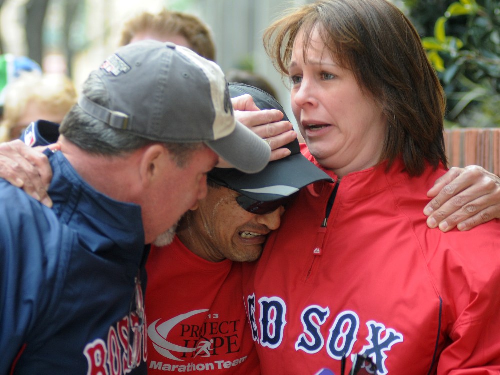 Runner John Ounao crying when he finds friends after several explosions rocked the finish of the Boston Marathon in Boston, Massachusetts, on April 15, 2013. (Photo by John Mottern/AFP/Getty Images)