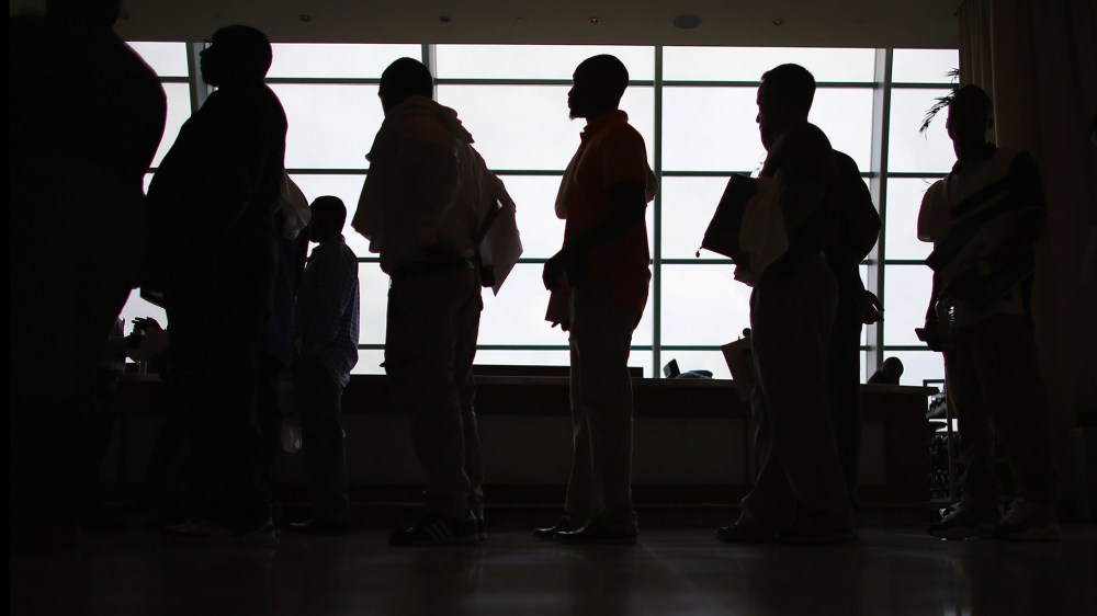 People looking for work stand in line to apply for a job during a job fair at the Miami Dolphins Sun Life stadium in Miami, Fla. (Photo by Joe Raedle/Getty)