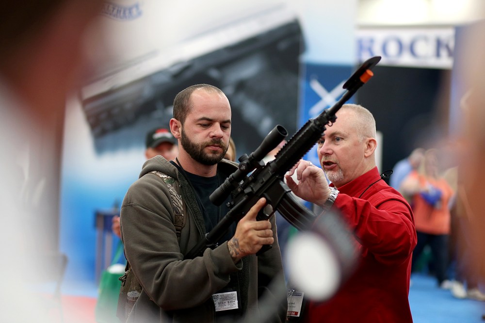 An attendee inspects a scope on an assault rifle during the 2013 NRA Annual Meeting and Exhibits in Houston, Texas, May 3, 2013.