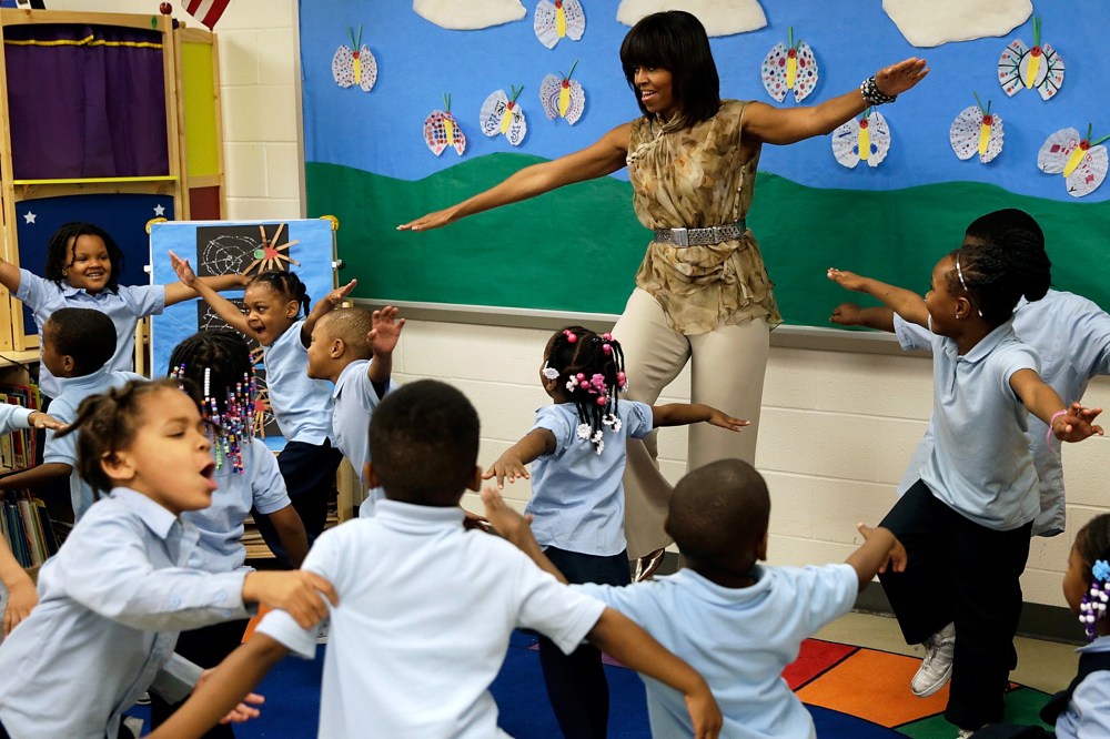 U.S. first lady Michelle Obama dances with pre-kindergarten students while she visits the Savoy School in D.C., May 24, 2013.