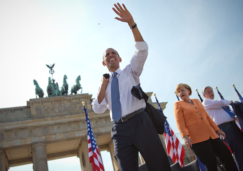 German Chancellor Angela Merkel (C) and Berlin's mayor Klaus Wowereit look on as US President Barack Obama waves to invited guests in front of Berlin's landmark the Brandenburg Gate near the US embassy on June 19, 2013. US President Barack Obama walks...