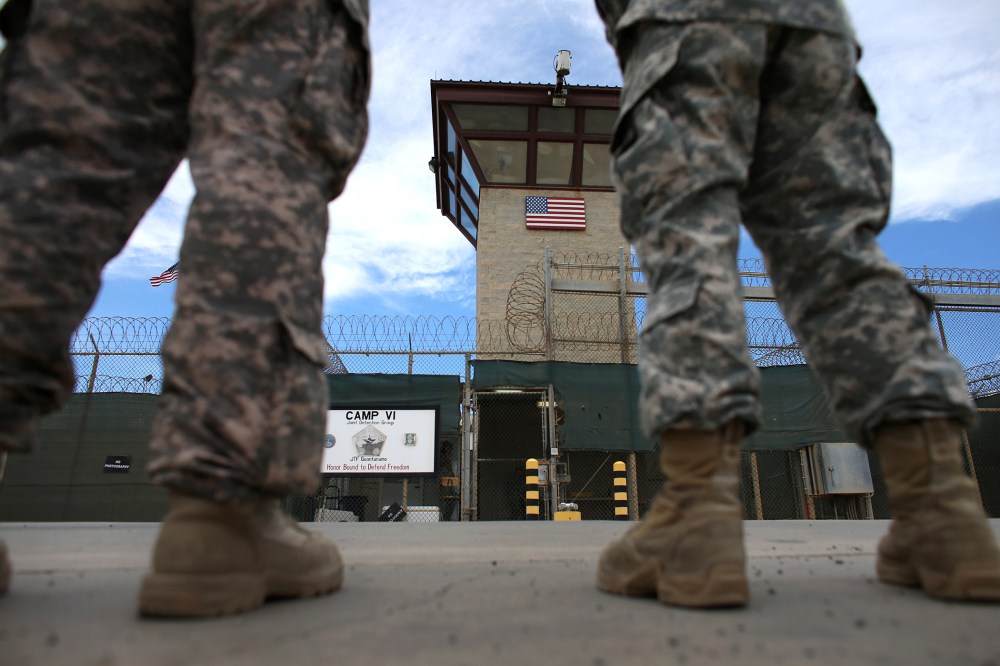 Military officers stand at the entrance to Camp VI and V at the U.S. military prison for 'enemy combatants' on June 25, 2013 in Guantanamo Bay, Cuba.