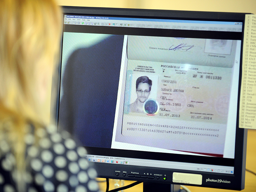 A woman watches a footage on her computer, showing the lawyer of fugitive US intelligence leaker Edward Snowden holding his client's one year's asylum permit at Sheremetyevo airport in Moscow on August 1, 2013. (Photo by Stringer/AFP/Getty)