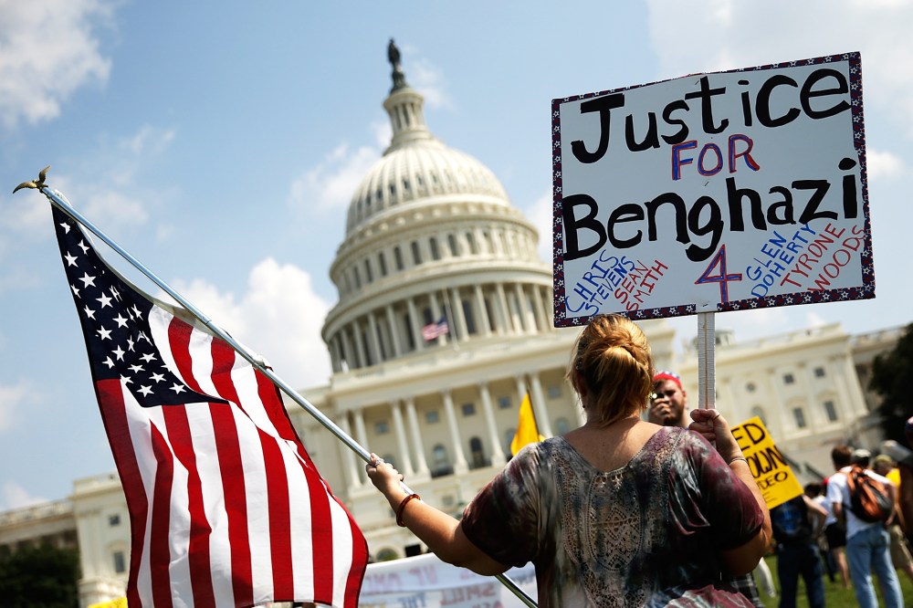 A woman holds signs during a "Call to Action" rally at the U.S. Capitol, marking the one year anniversary of the attacks on the U.S. compound in Benghazi, Sept. 11, 2013.