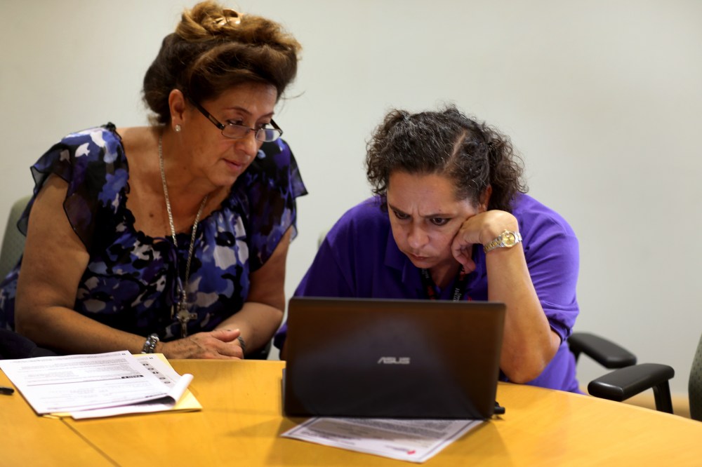 Affordable Care Act navigator Nini Hadwen (R) works with Marta Aguirre as she shops for health insurance during a navigation session put on by the Epilepsy Foundation Florida to help people sign up for health insurance under the Affordable Care Act on Oct
