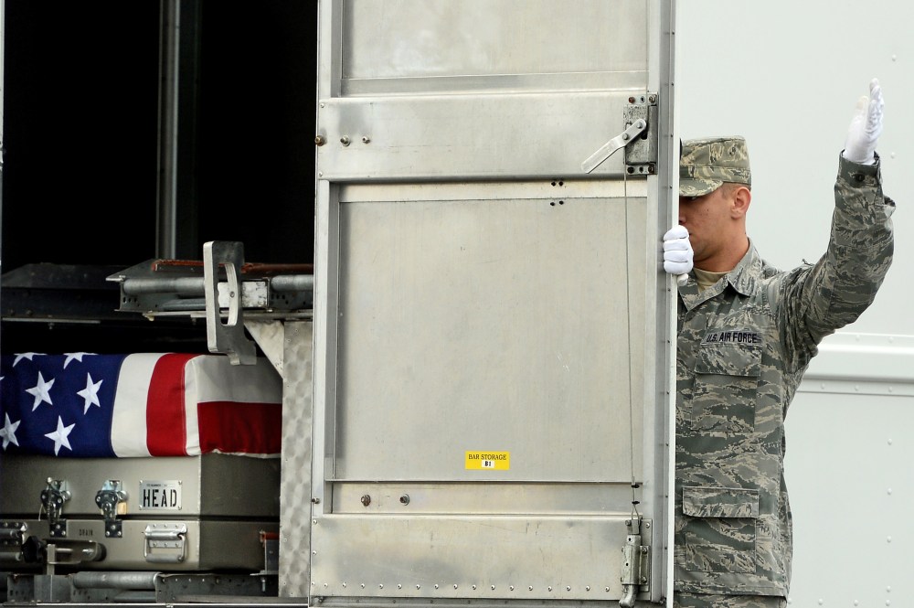 U.S. Army soldiers carry the flag-draped transfer case containing the remains of U.S. Army Pfc. Cody J. Patterson during a dignified transfer at Dover Air Force Base on October 9, 2013 in Dover, Delaware.