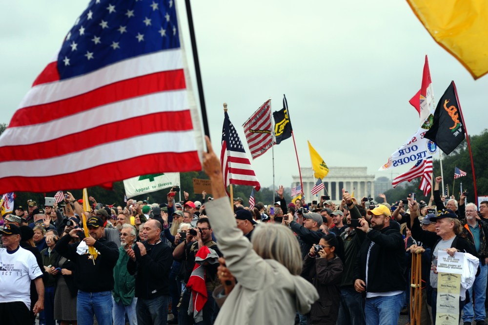 Protesters wave flags during a demonstration at the World War II memorial in Washington, DC, on Oct. 13, 2013 demanding for an end of US federal government shutdown.