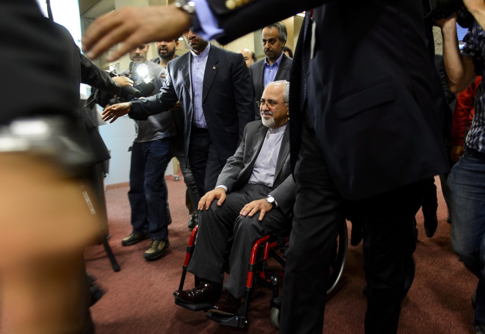 Iranian Foreign Minister Mohammad Javad Zarif leaves with a weelchair a press conference closing a two-day of closed-door nuclear talks on October 16, 2013 in Geneva.
